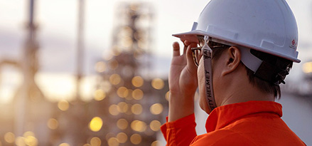Ein ExxonMobil-Mitarbeiter blickt auf eine Raffinerie